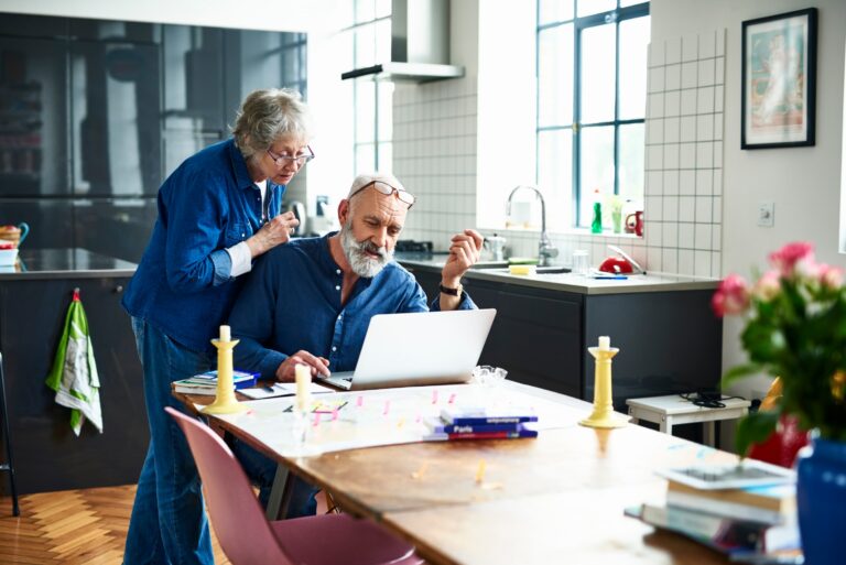 Senior Couple Kitchen Table Laptop