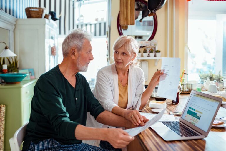 Senior Couple Paperwork Computer Kitchen